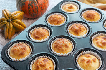 Top view and close up group homemade pumpkin muffins on wooden plank. Autumn dessert and recipes.