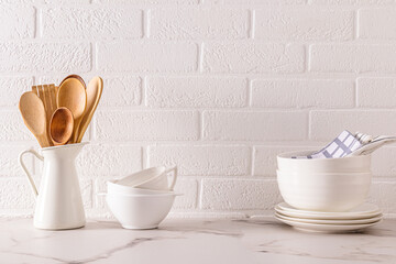 Kitchen background in minimalist white style. Beautiful white dishes on the background of a white brick wall. ecologically clean kitchen. Zero waste.