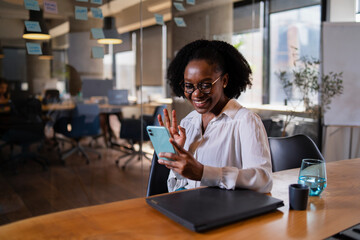 Black businesswoman working on laptop. Portrait of beautiful businesswoman in the office. Woman using the phone..