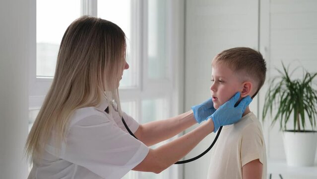 Doctor of incidence of lymph nodes in a child. The nurse examines the throat of a little boy.