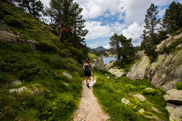 Fototapeta premium Young hiker girl summit to Ratera Peak in Aiguestortes and Sant Maurici National Park, Spain