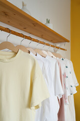 Fototapeta na wymiar Women's t-shirts on hangers in the dressing room, interior design