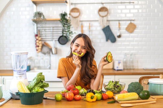 Portrait of beauty body slim healthy asian woman having fun hold avocado cooking preparing vegan food healthy eat with fresh vegetable salad, vegetarian in kitchen at home.Diet.Fitness, healthy food