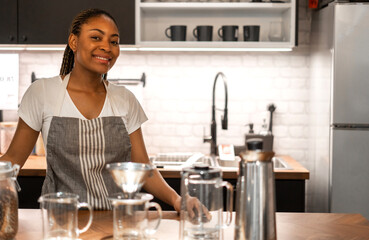 Portrait of african american barista woman small business owner working behind the counter bar and  receive order from customer on coffee packaging and cup of coffee background in cafe or coffee shop