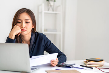 Smiling asian woman using calculator and calculate bills on laptop, paying bill, credit card,...