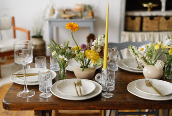 serving the table with fresh flowers and candles