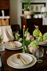 serving the table with fresh flowers and candles