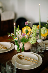 serving the table with fresh flowers and candles