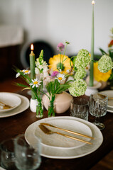 serving the table with fresh flowers and candles