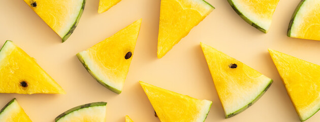 Sliced yellow watermelon pattern flat lay on pastel yellow table background.