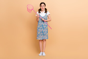 Full body cadre of young waiting girl wear skirt stay meadow hold fishnet look empty space dreaming isolated on beige color background