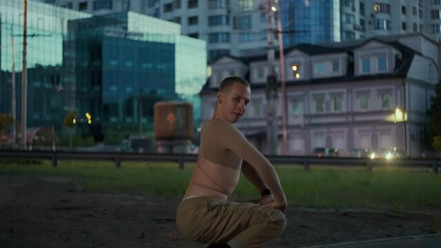 A handsome dancer is dancing on high heels in a cityscape. A man in high heels moves to the rhythm and beat of the music. High quality 4k footage
