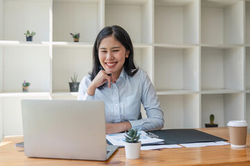 Young happy professional business woman working on laptop in office sitting at desk, business female portrait at workplace