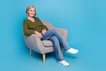 Full body photo of good mood pensioner grey hair woman sitting comfort furniture interview her candidates isolated on blue color background