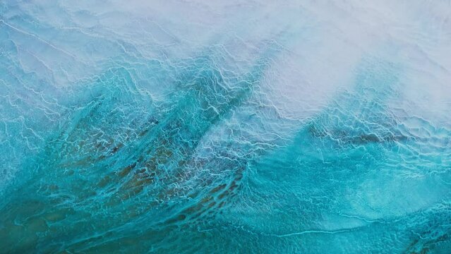 Artistic video painted with liquid acrylic paints. Fluid art for background, wallpapper or theme. Backdrop similar to the landscape of the ocean. Sea artwork with turquoise waves and white foam.