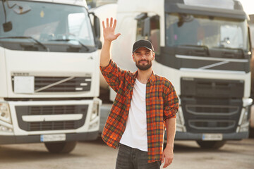 Hello gesture by a hand. Young truck driver in casual clothes © standret