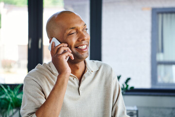 myasthenia gravis disease, bold african american man at work, cheerful and dark skinned office worker with ptosis syndrome talking on smartphone, inclusion, corporate culture