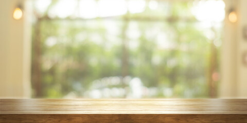 Empty wooden table top with blurred coffee shop or restaurant interior background. Panoramic background.