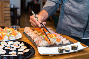 Overhead japanese sushi food. Maki ands rolls with tuna, salmon, shrimp, crab and avocado. Top view of assorted sushi.