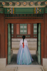 Tourist girl wearing traditional korean hanbok at the Gyeongbokgung Palace in Seoul, South Korea.
