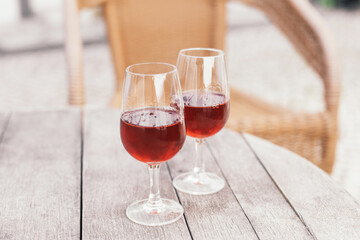 Two glasses of alcoholic beverage - Portuguese sweet wine Moscatel on a wooden table in a vineyard cafe terrace 