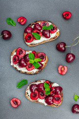 Fresh bread sandwiches with sweet cherry, cream cheese and mint leaves. Morning breakfast concept