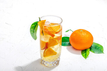 Orange cocktail with ice and ripe fruits. Refreshment seasonal drink, conceptual background
