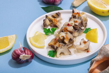 Pickled rapan meat with oil, spices and greens. Healthy seafood rich of omega