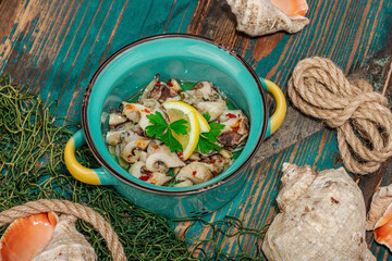 Rapana clam meat with oil, spices and greens. Healthy seafood rich of omega. Marine decor