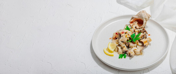 Rapana clam meat with oil, spices and greens. Healthy seafood is rich in omega. Marine decor