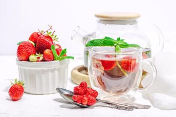 Strawberry tea concept. Good morning concept. Teapot, ripe fruits, healthy beverage