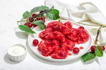 Dumplings, filled fresh cherries. Ripe fruits, sweet sauce, sour cream. Traditional Ukrainian dish