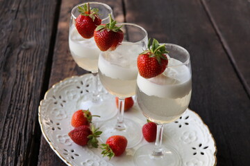 Glass of strawberry cocktail or mocktail, refreshing summer drink with champagne, strawberries, ice  cream