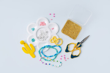 Set of for needlework and beading. Kids handmade beaded jewelry and different multi-colored beads for children's crafts in boxes. DIY art activity for kids. Motor skills, creativity and  hobby.