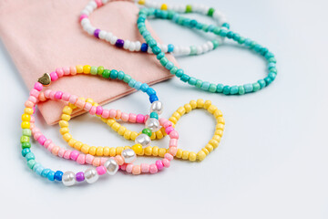 Kids handmade beaded jewelry. Necklaces and bracelets made from multicolored beads and pearls. DIY...