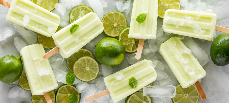 Key lime popsicles with lime slices and ice cubes.