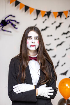 Young woman in carnival costume of movie doll at Halloween party