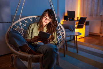 Woman relaxing at home reading an e-book