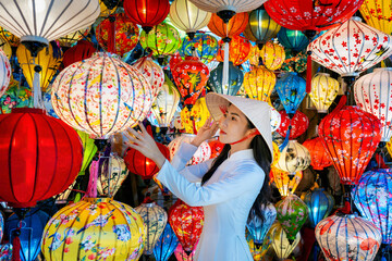 Asian woman wearing vietnam culture traditional and hoi an lanterns at Hoi An ancient town, Vietnam. - obrazy, fototapety, plakaty