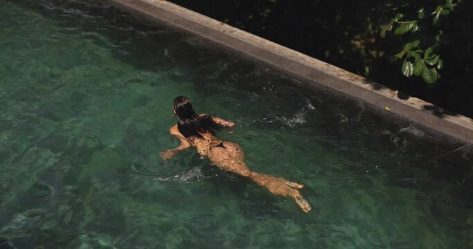 Swimming Bikini Woman in Black Swimsuit in the Private Luxury Pool Outdoors
