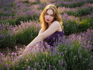 beautiful blonde girl with long hair on a lavender field in the evening - 625566964