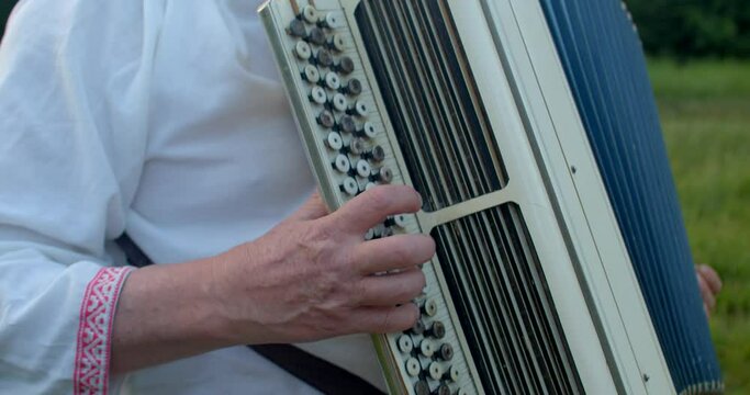 Closeup playing button accordion, celebration of national Slavic holiday. Man playing musical instrument lifestyle. Eastern Europe traditions cultural historical roots. Rich cultural heritage folklore