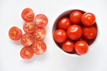 Fresh red fruits of small tomatoes on a glass plate. Juicy chopped cherry tomatoes.