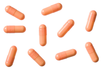 Orange capsules isolated on white background, top view.