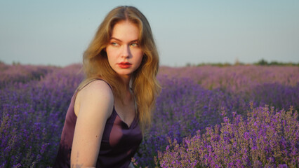 beautiful blonde girl with long hair on a lavender field in the evening - 625568922