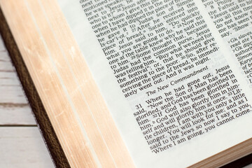 New commandment verse in open holy bible book with golden pages. Closeup. Christian love, growth,...