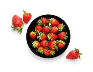 Berries of organic strawberries in a black round plate isolated on white background, top view.