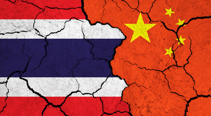 Flags of Thailand and China on cracked surface - politics, relationship concept