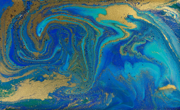 Golden Dust on Liquid Blue Ink Wave Background. © anya babii