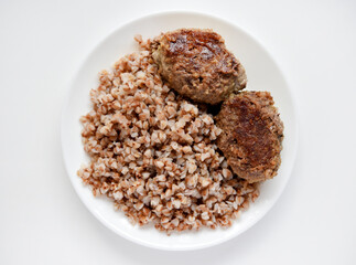Buckwheat porridge with meat patty. Delicious meat breakfast on a plate.